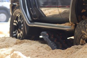 Closed-up of 4WD tyres parked on a sand.