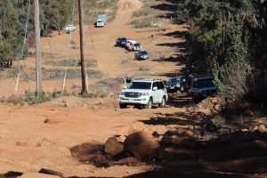 A team of 4WD vehicles/trucks travelling as a convoy in an off-road track.