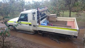 White coloured 4X4 pick up driving at muddy track.