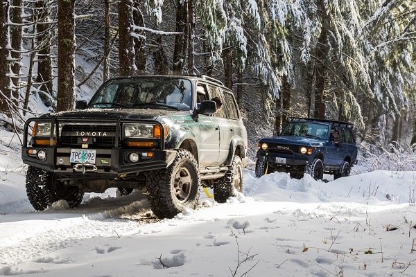 2 vehicles towing on a snow tracks.